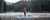 Man wearing a orange jacket paddle boarding on a lake