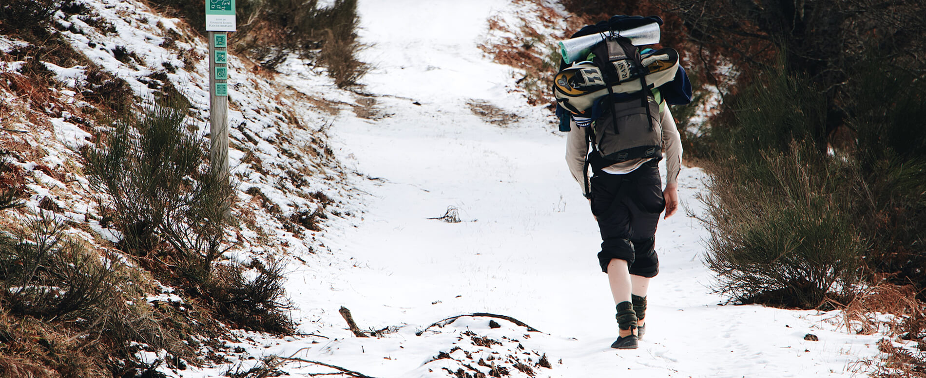 Man walking on a snow while wearing a snow shoes