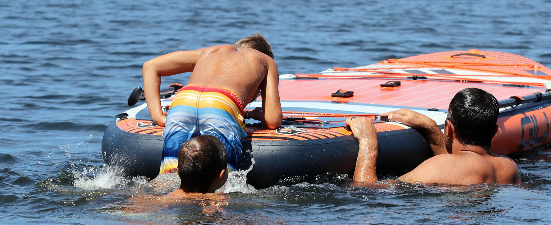 Family getting on their large inflatable paddle board