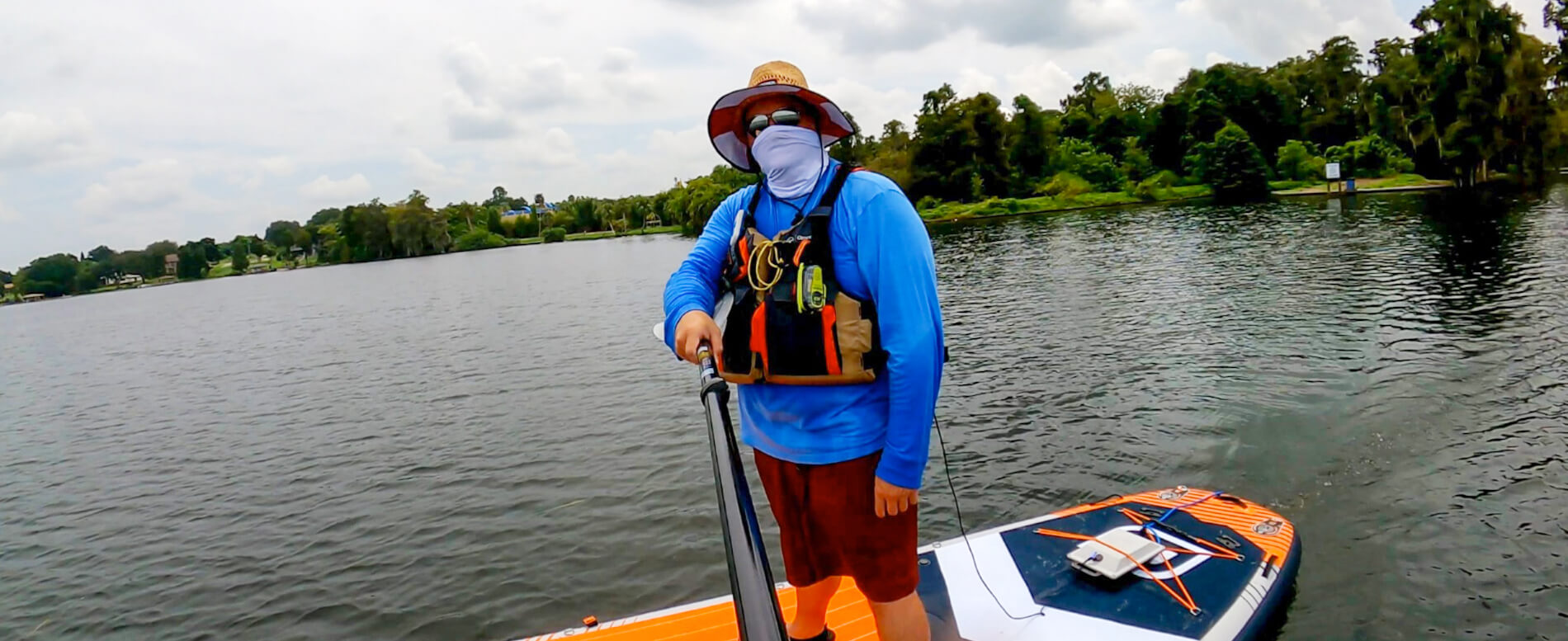 Man wearing an Onyx MoveVent life jacket while paddle boarding