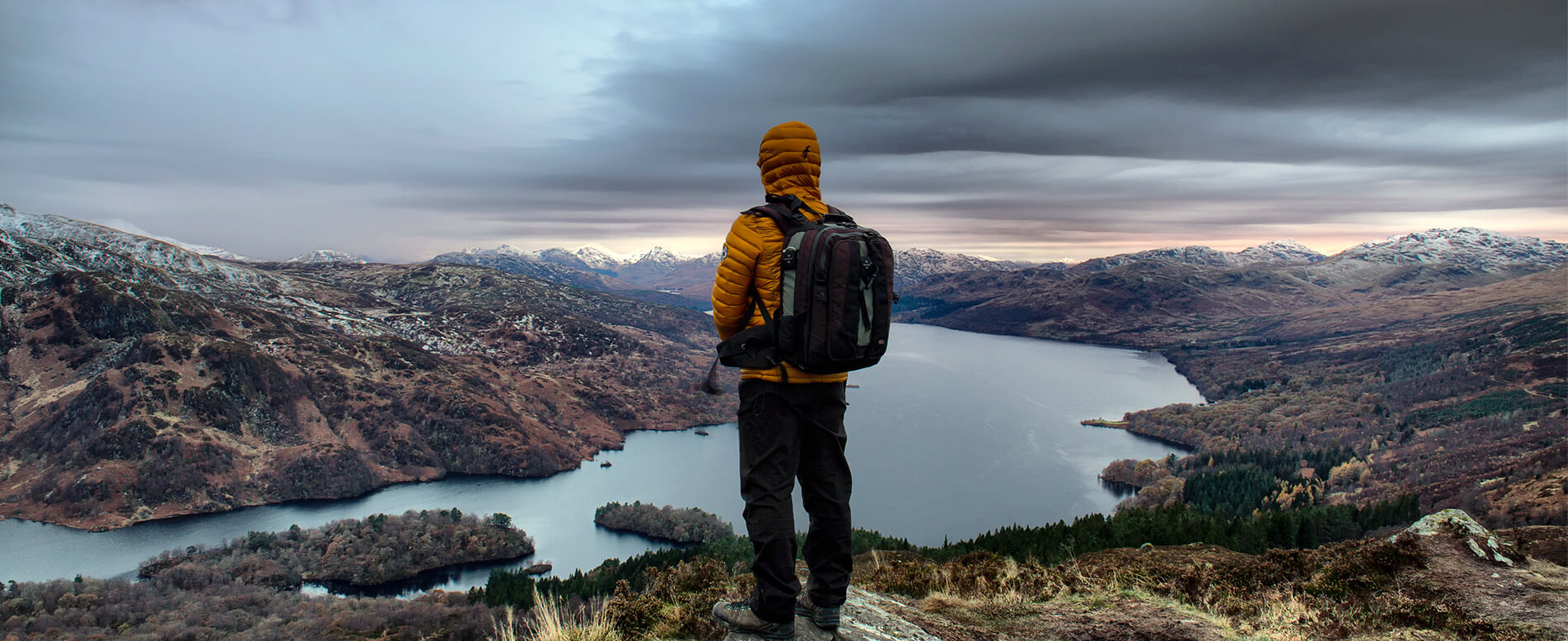 Man looking at a lake with a waterproof backpack